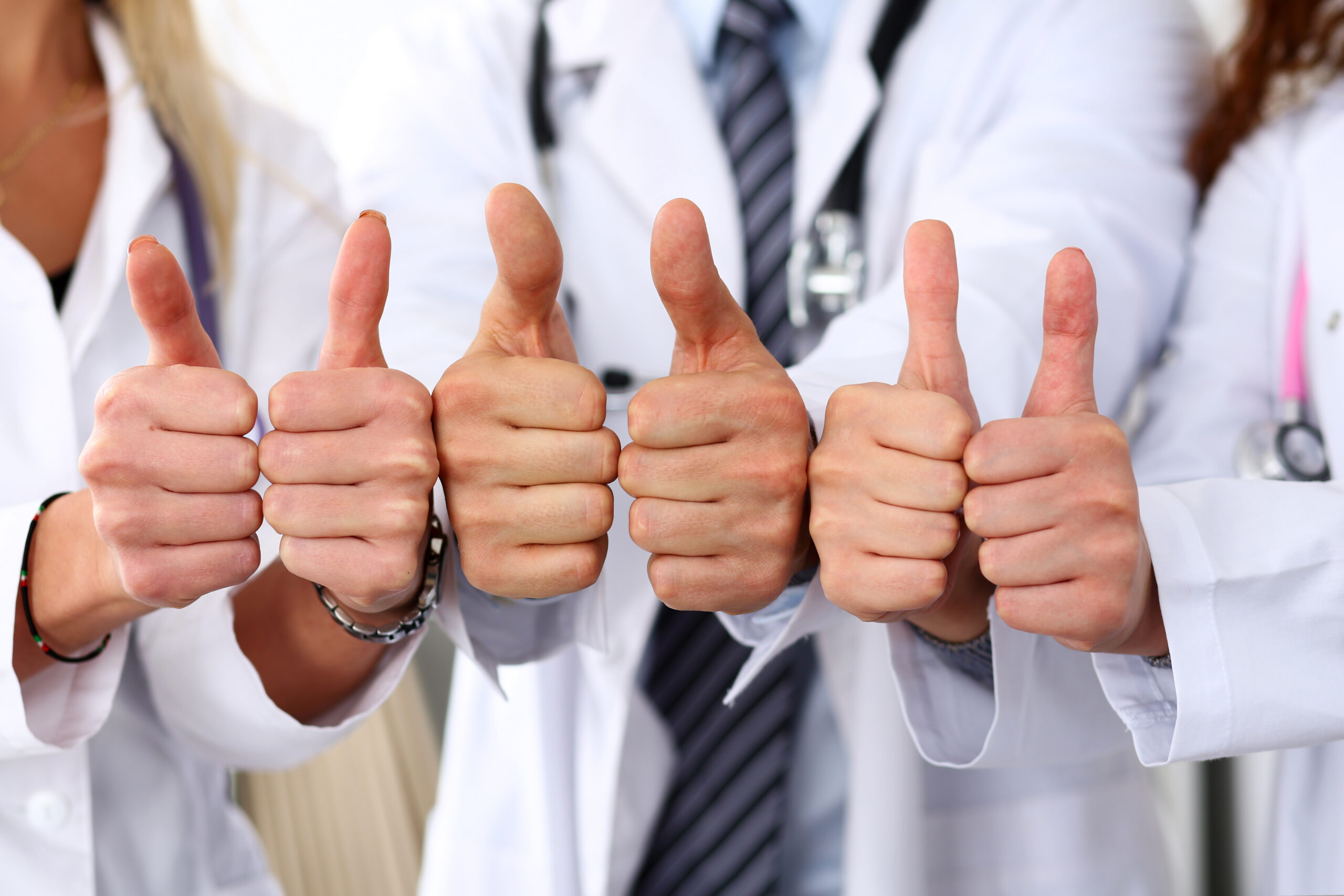 Three medicine doctors show OK sign with thumb up in row. High level service, best treatment, 911, healthy lifestyle, satisfied patient, therapeutist consultation, work and career, physical concept